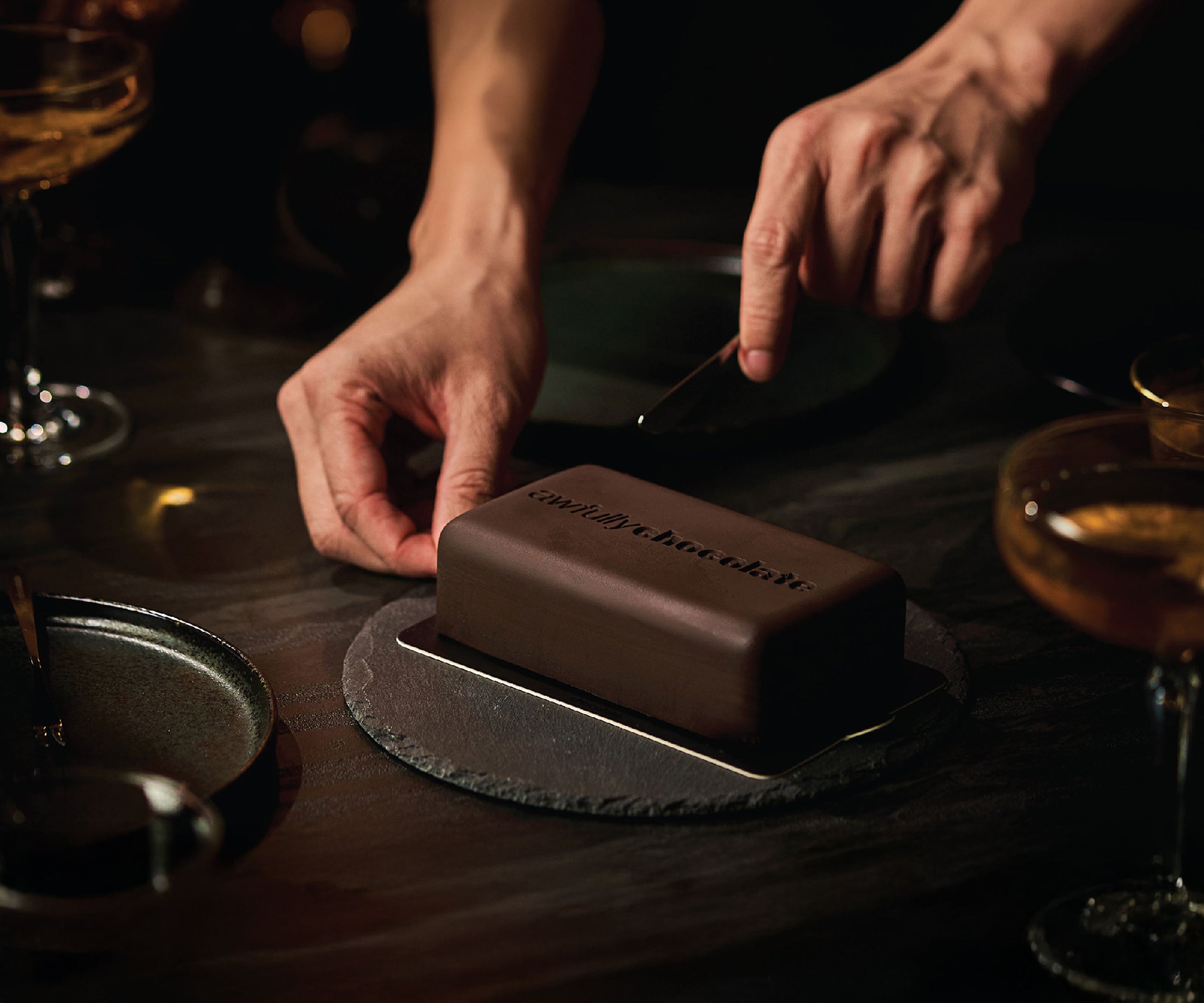 Hands cutting awfully chocolate cake